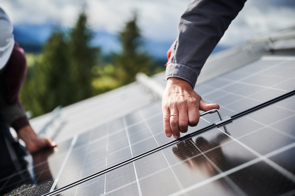 Professional workers securing solar cell on a roof.
